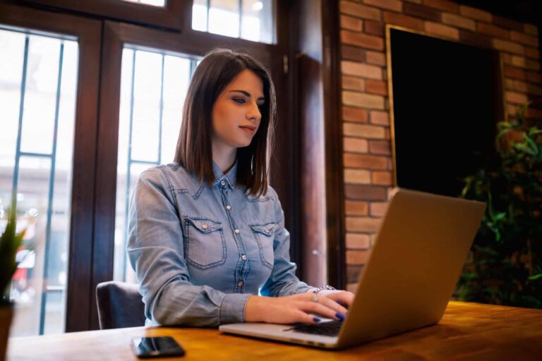 Woman writing content on laptop remotely