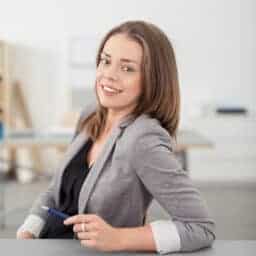 Square photo example: smiling businesswoman leaning on her desk