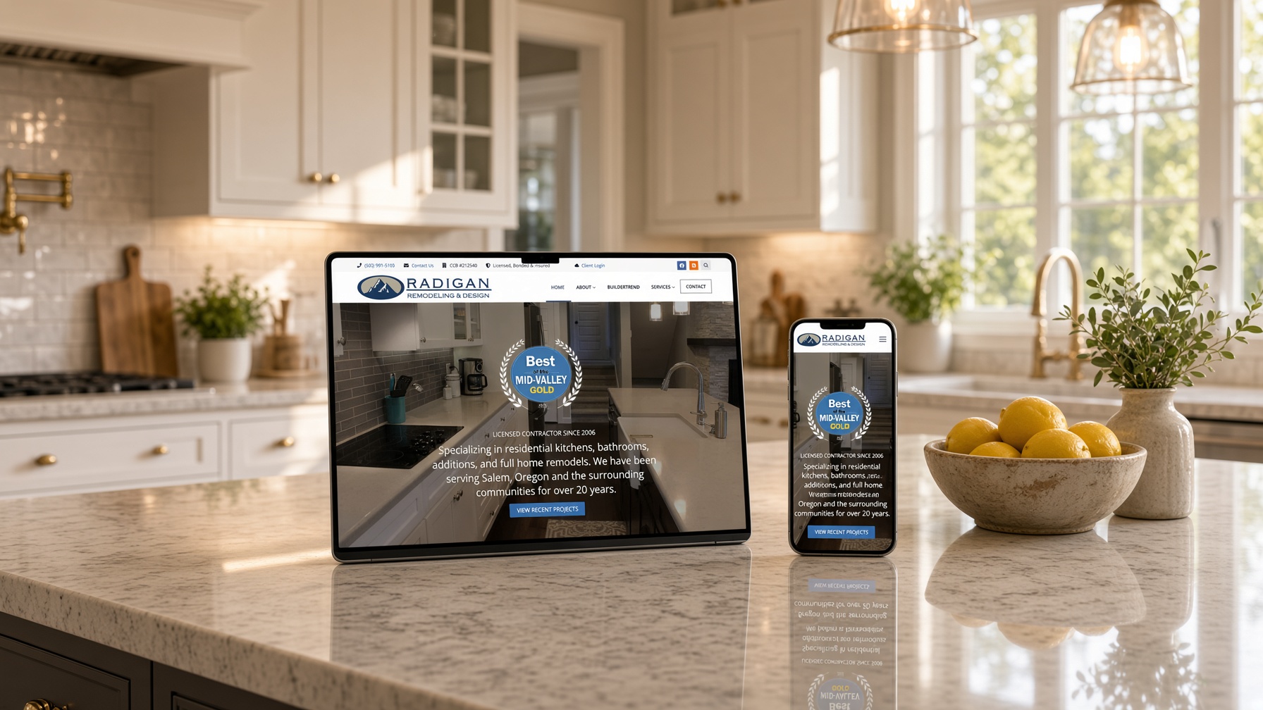Radigan Remodeling website on tablet and phone on the granite island of a remodeled farmhouse kitchen