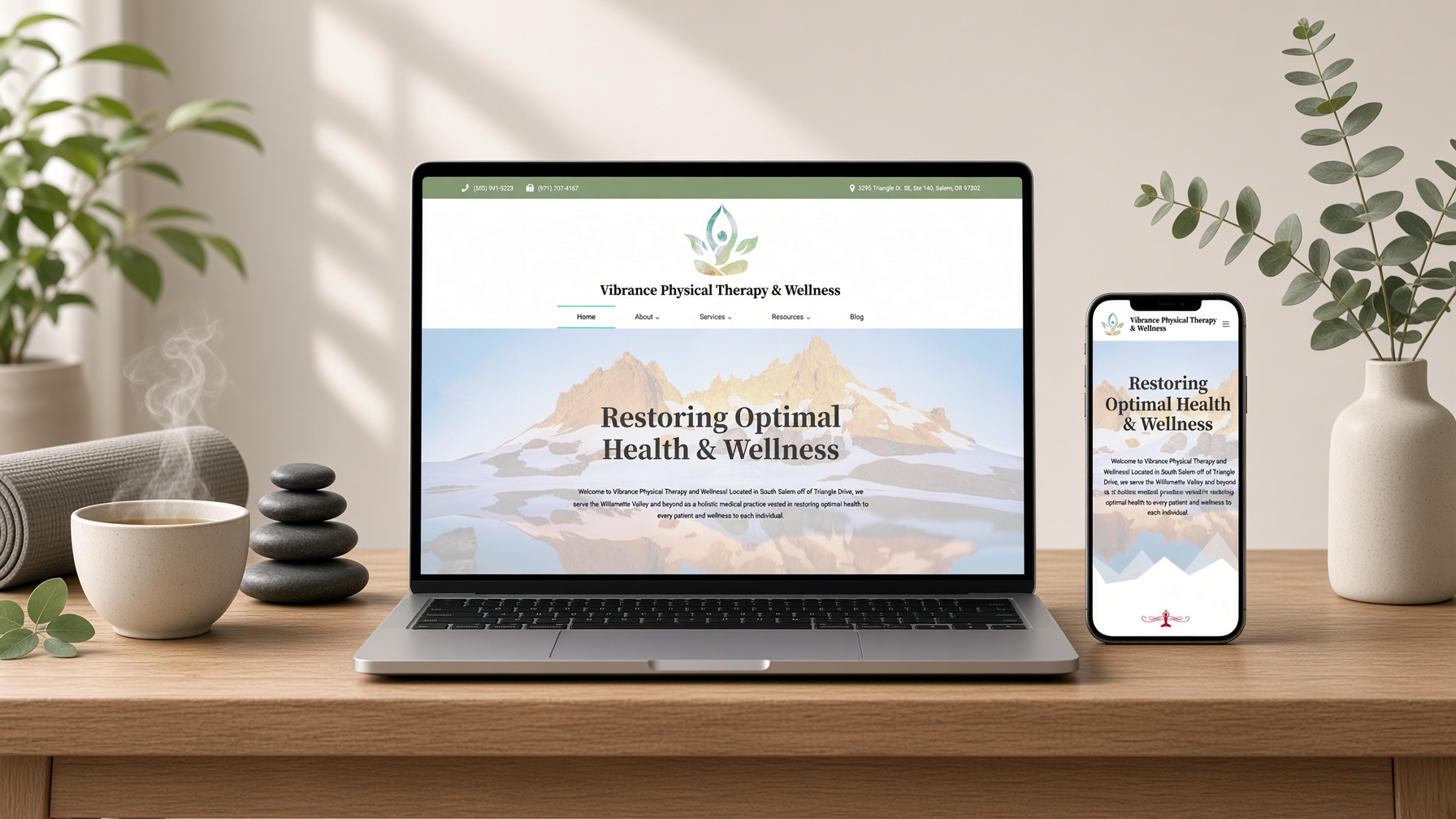 Vibrance Physical Therapy website on laptop and phone on a wooden console with herbal tea, river stones and eucalyptus